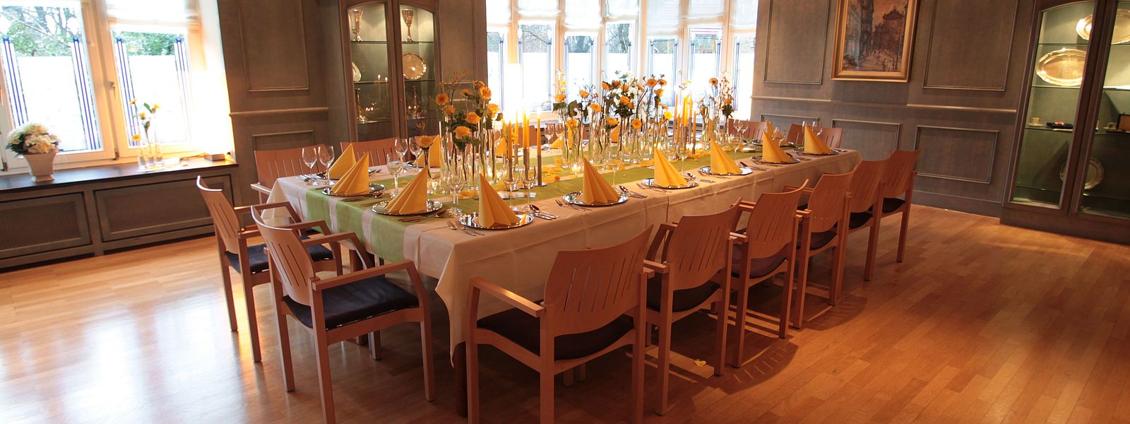 Festtafel im Blauen Zimmer mit gelben Blumen, Servietten und Kerzen