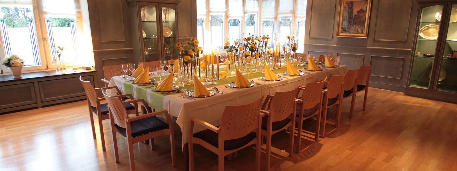 Festtafel im Blauen Zimmer mit gelben Blumen, Servietten und Kerzen