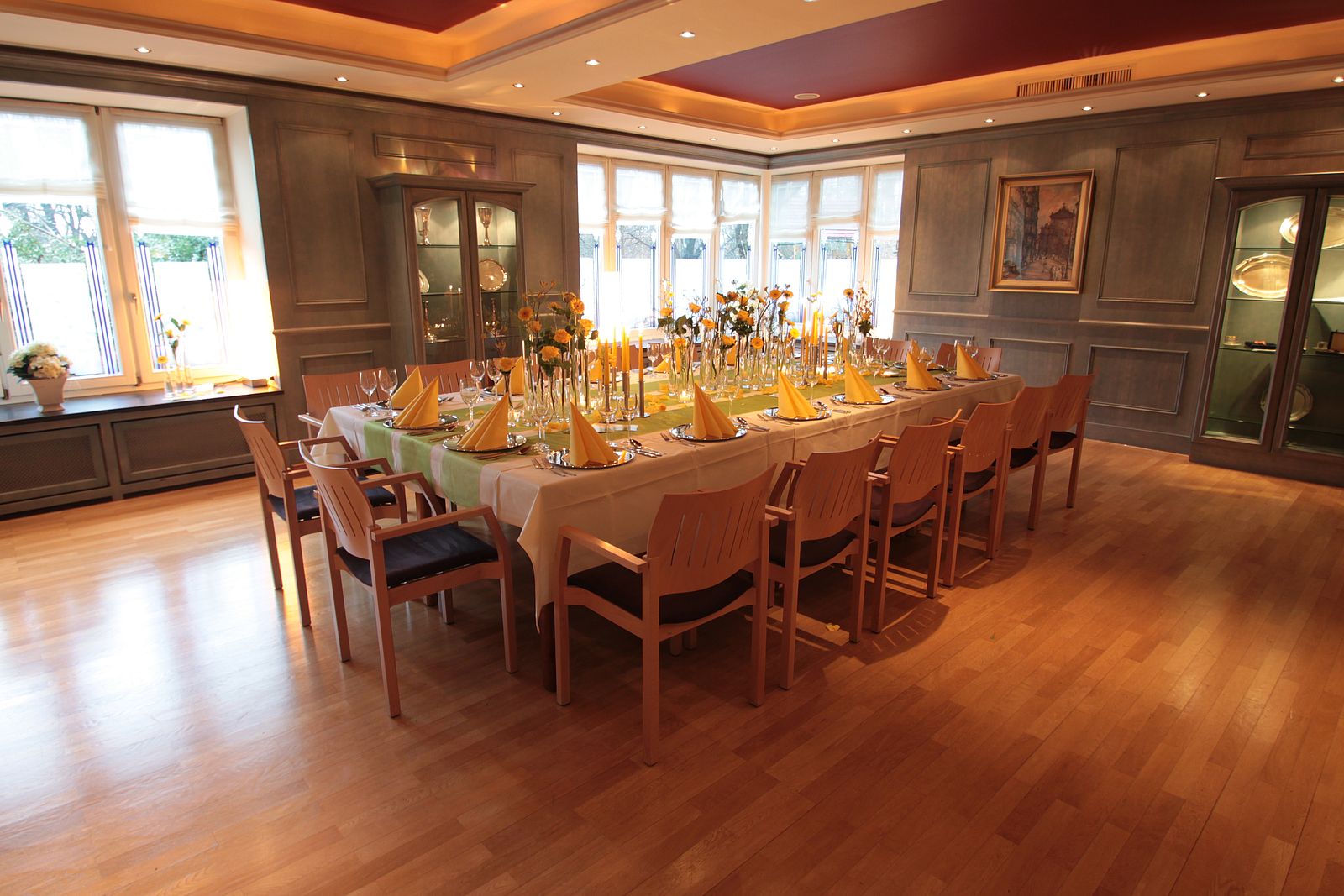 Festtafel im Blauen Zimmer mit gelben Blumen, Servietten und Kerzen