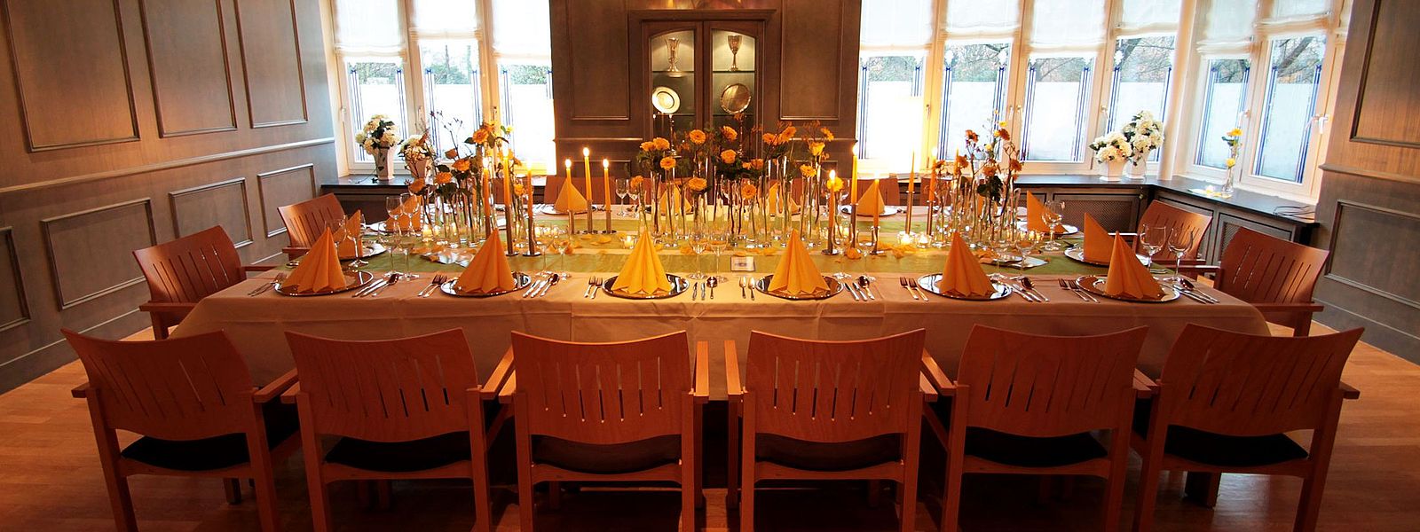 Festtafel im Blauen Zimmer mit gelben Blumen, Servietten und Kerzen