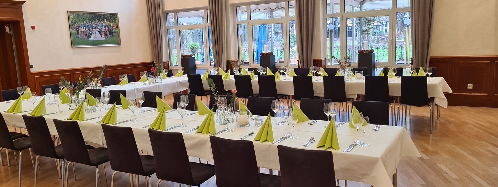 Festtafel in U-Form im Fahnensaal mit grüner Dekoration