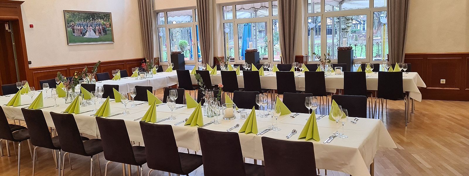 Festtafel in U-Form im Fahnensaal mit grüner Dekoration