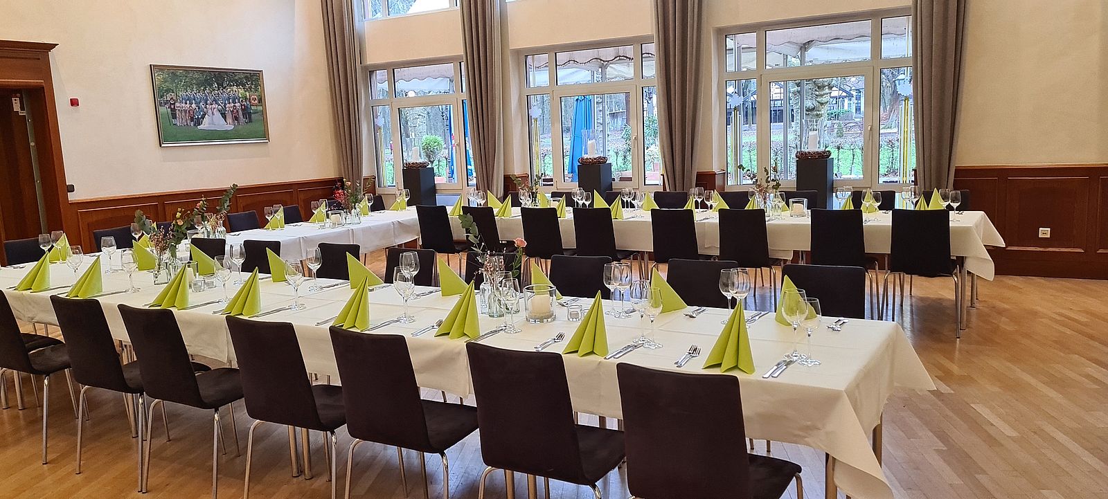 Festtafel in U-Form im Fahnensaal mit grüner Dekoration