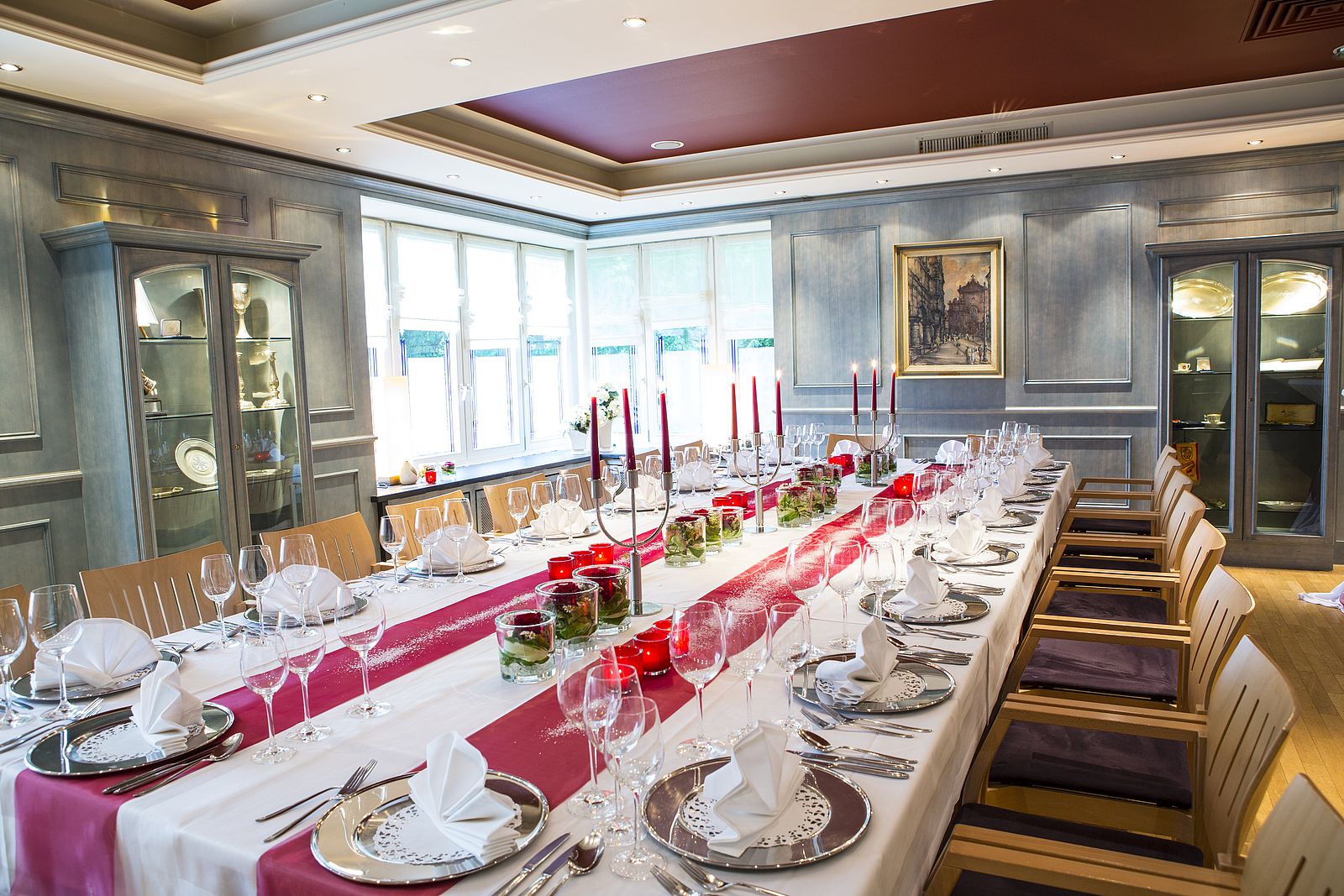 Festtafel im Blauen Zimmer mit silbernen Platztellern und rot-weißer Dekoration