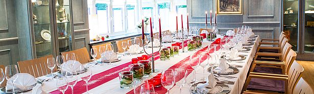 Festtafel im Blauen Zimmer mit silbernen Platztellern und rot-weißer Dekoration