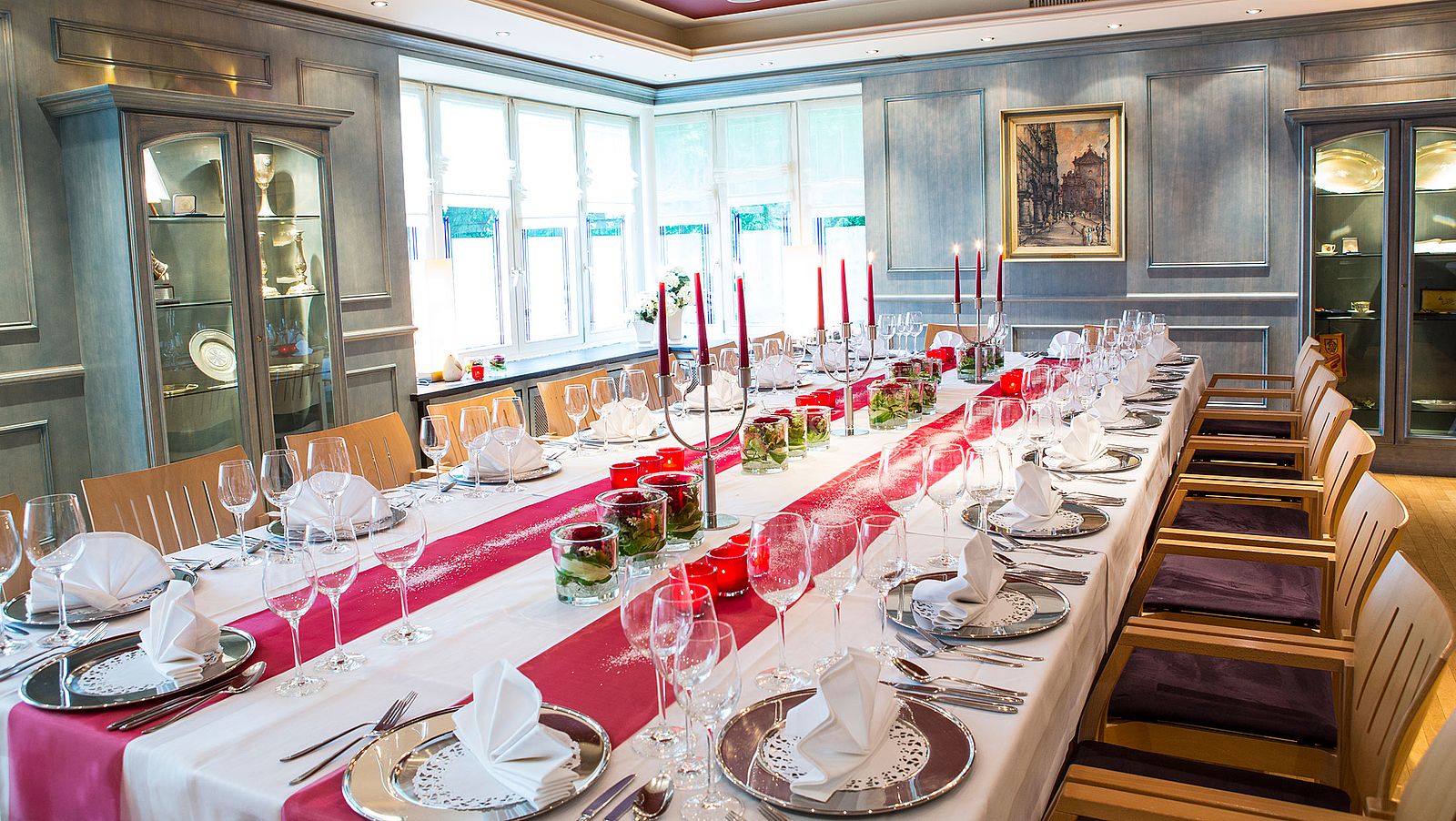 Festtafel im Blauen Zimmer mit silbernen Platztellern und rot-weißer Dekoration